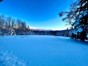 un campo cubierto de nieve con huellas en la nieve en The Vermont Inn, en Mendon