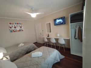 カルダス・デ・レイスにあるVía Romanaのベッドルーム1室(ベッド2台、テーブル、テレビ付)