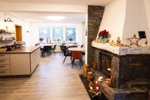 a kitchen and a living room with a fireplace at Landhaus am Itterbach Willingen in Willingen
