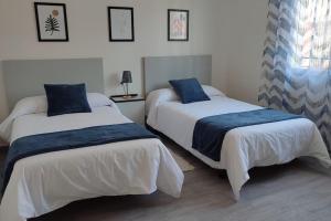a bedroom with two beds with blue pillows on them at La Casa del Cerrillo in Sonseca +45 photos