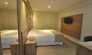 A bed or beds in a room at Apart 707&709 no MontBlac Suites - Duque de Caxias