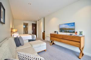 
a living room with a bed and a television at The Rees Hotel & Luxury Apartments in Queenstown
