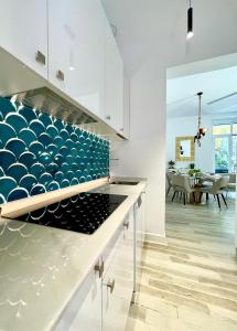 una cocina con armarios blancos y una pared azul en BNBHolder EL RETIRO es MIA, en Madrid