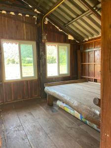 a room with a bench in a room with windows at บ้านสวนวิวทุ่ง in Ban Mae Sap Nua