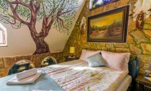 a bedroom with a tree mural on the wall at CamPetrus- Dom Krawca in Ciche