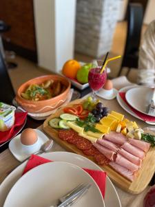 a table topped with a tray of food with meats and vegetables at Guest House Panorama Aqualux in Novi Sad