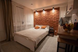 sypialnia z łóżkiem i ścianą z cegły w obiekcie Apartament Jasnogórska w mieście Częstochowa