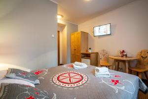a bedroom with a bed and a table with chairs at Willa Cicha Woda Centrum in Zakopane