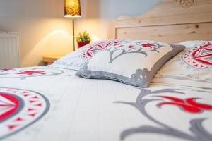 Una cama con almohadas rojas y blancas. en Willa Cicha Woda Centrum, en Zakopane