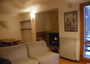 a living room with a white couch and a fireplace at Appartamento Cerreto Laghi in Cerreto Laghi