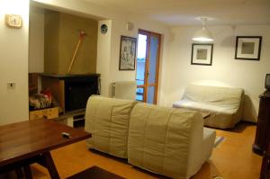 a living room with a couch and a bed at Appartamento Cerreto Laghi in Cerreto Laghi