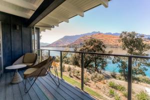 a balcony with a view of the water and mountains at The Rees Hotel & Luxury Apartments in Queenstown