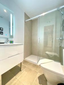 een badkamer met een douche, een toilet en een wastafel bij BNBHolder PUERTA DE ALCALA es MIA in Madrid