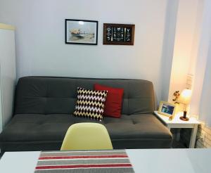 Kitnet aconchegante Beira Mar. في سانتوس: غرفة معيشة مع أريكة خضراء وكرسي اصفر