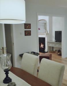 een woonkamer met een tafel en stoelen en een open haard bij Castlebar 3 bedroom house in Castlebar