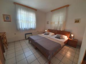 a bedroom with a large bed and two windows at Apartments Villa Anne in Jadranovo +57 photos