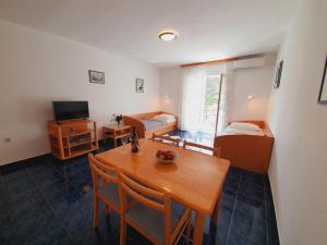 a room with a dining table and a bedroom at Apartments Villa Anne in Jadranovo