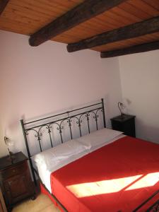 クストナーチにあるBaglio Baia Corninoの赤いベッドと木製の天井が備わるベッドルーム1室が備わります。