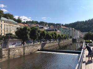 a group of people standing on a bridge over a river at Bella Vista Collonade in Karlovy Vary