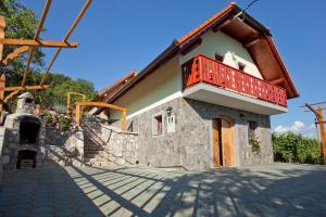 a house with a balcony on top of it at Vineyard Cottage Lustek in Novo Mesto