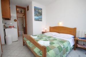 a bedroom with a bed with a green and white quilt at Apartments Mile - 10m from the sea in Lastovo