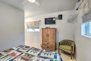 a bedroom with a bed and a chair and a tv at Cozy Studio in Downtown Williams with Patio! in Williams