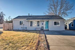 a white house with a driveway in front of it at Comfy Aurora Hideout with Yard and Covered Patio! in Aurora