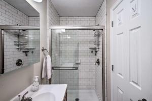 a white bathroom with a shower and a sink at Centrally Located Aurora Home w/ Covered Patio in Aurora +19 photos