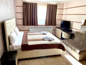 a hotel room with a bed and a couch at Alpine Luxe Janosevic Kopaonik 011 in Kopaonik