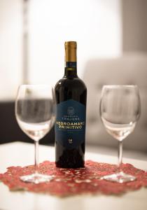 a bottle of wine next to two glasses on a table at Apartament Krakowska in Częstochowa +3 photos