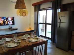 una cucina con un tavolo di legno e un frigorifero di Aruna - Casa de Charme com piscina privativa a São Miguel dos Milagres