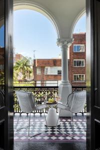 a patio with two chairs and a table on a balcony at Hotel Challis Potts Point in Sydney