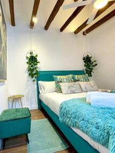 ein Schlafzimmer mit einem blauen Bett und einer blauen Ottomane in der Unterkunft BNBHolder JARDIN BOTANICO es MIA in Madrid