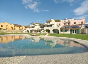 una grande piscina d'acqua di fronte ad alcune case di Barbaciiu Vacanze Green a Pietra Ligure