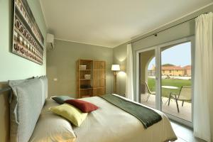 a bedroom with a bed and a sliding glass door at Barbaciiu Vacanze Green in Pietra Ligure
