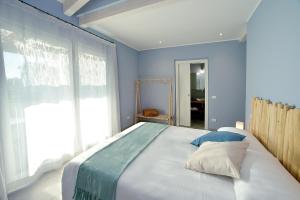 a bedroom with a large bed with a large window at Barbaciiu Vacanze Green in Pietra Ligure