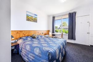 a bedroom with a bed and a desk and a window at Tamworth Budget Motel in Tamworth +14 photos