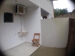 a chair sitting in a room next to a wall at Pousada Dunas Da Joaquina in Florianópolis