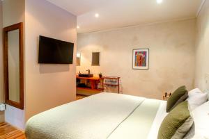 Schlafzimmer mit einem Bett und einem Flachbild-TV in der Unterkunft Woodstock Suite in Nelson