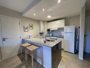 a kitchen with a counter and a refrigerator at Apart Ribera, Rio Cuarto in Río Cuarto
