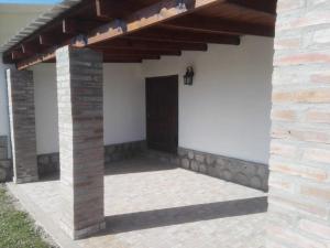 eine Veranda eines Hauses mit einer Holztür in der Unterkunft Casa de Verano en Tafi del Valle in Tafí del Valle + 2 Fotos