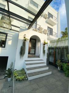 une maison blanche avec des escaliers en face de celle-ci dans l'établissement Loewys Home Tanjung Duren Jakarta Barat, à Jakarta