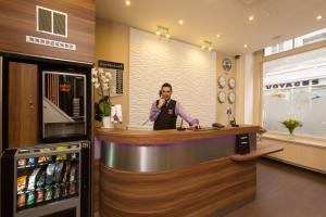 un homme debout dans un bar d'un magasin dans l'établissement Grand Hotel du Loiret, à Paris