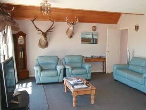 - un salon avec deux chaises bleues et une table dans l'établissement Creel House Bed and Breakfast, à Lac Tekapo