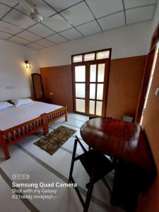 1 dormitorio con cama, escritorio y ventana en La-Vira Beach Villa en Hikkaduwa