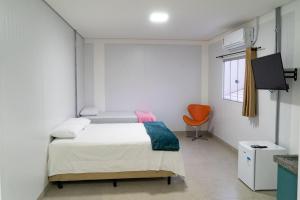 a bedroom with a bed and a orange chair at Flat Central in Bonito
