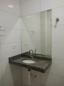 uma casa de banho com um lavatório e um espelho em Flat Central em Bonito