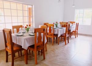 uma sala de jantar com mesas brancas e cadeiras de madeira em Sommerville Resorts em Negril