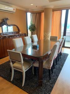 Times Square Kuala Lumpur JN في كوالالمبور: طاولة غرفة الطعام مع كراسي بيضاء حولها