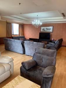 Times Square Kuala Lumpur JN في كوالالمبور: غرفة معيشة كبيرة مع كنب وبيانو